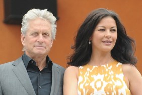 Michael Douglas, gray suit jacket, black dress shirt, Catherine Zeta-Jones, orange and white print dress, earrings